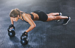 Girl with dumbbells pressed on the floor